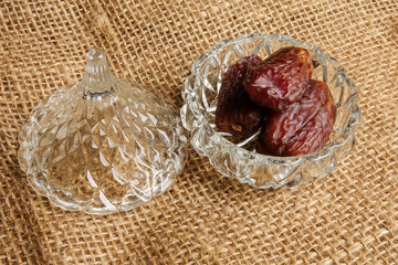 Date in a glass container on a rug background.