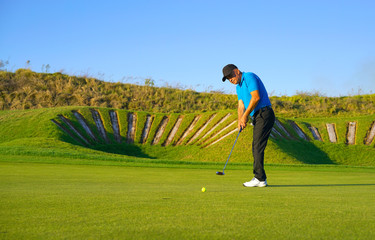 Fototapeta premium Golf player is swinging at links golf course 