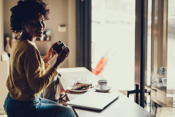 Lady holding her camera in hands and smiling