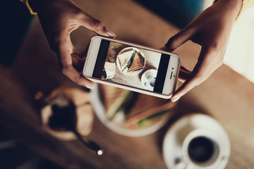 Lady making photo of her food in cafe