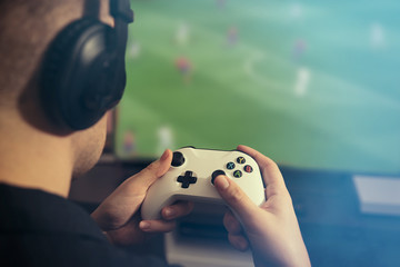 Video gaming console. Man playing soccer game