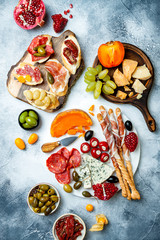 Appetizers table with antipasti snacks. Brushetta or authentic traditional spanish tapas set, cheese and meat platter over grey concrete background. Top view