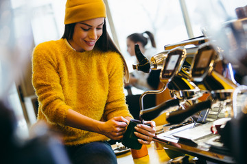 Portrait of a female barista steaming milk at the coffee shop