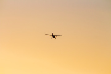 small airplane flying at sunset