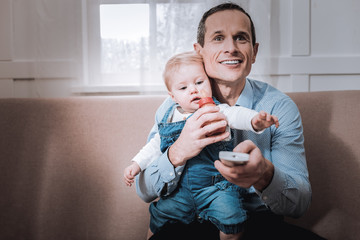 Nice happy man holding a remote control