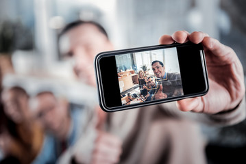 Inspired man taking a selfie with his colleagues