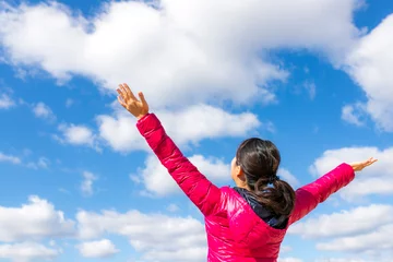 Foto op Plexiglas 青空に向かって両手を広げる女性 © beeboys