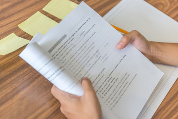 Close-up of student hands holding workbook and self studying