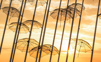 resort coats romantic concept background of umbrella silhouettes hanging on pillars on sunset vivid orange sky above the sea, beautiful wallpaper pattern