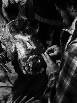 Detail of a carpenter carving a wooden traditional mask.