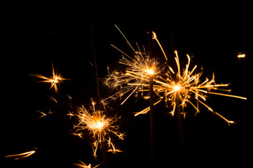 Fototapeta premium Light sparklers on holiday glare sparks texture background