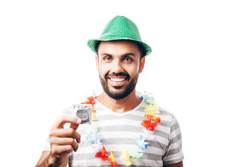 Portrait of young brazilian man wearing carnival costume showing a condom