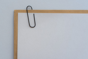 Leerer Briefkopf mit einem mit einer Büroklammer befestigten Umschlag vor weissen Hintergrund