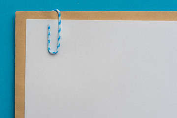 Leerer Briefkopf mit Anhang befestigt mit einer Büroklammer und blauen Hintergrund