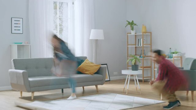 Time-Lapse: Happy Young Couple Moves into New Apartment, Arranges Furniture, Hanging Paintings, Exhausted Resting on Couch after Everything is Done. Modern House with Big Windows and Stylish Furniture