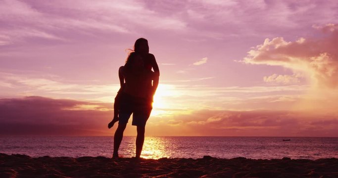 Couple on beach having fun happy doing piggyback enjoying sunset on romantic summer travel vacation holiday honeymoon.
