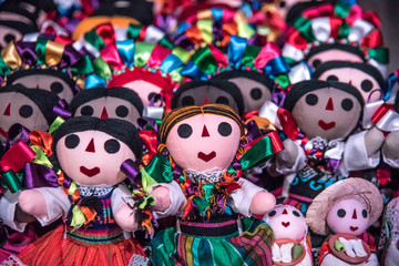 Fototapeta na wymiar muñecas mexicanas tradicionales, vestidas con listones coloridos y tiernas caras en un fondo colorido
