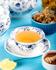 Cup of Linden Tea, Dried Linden Flowers in bowl with honey and lemon on wooden background