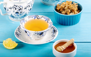 Cup of Linden Tea, Dried Linden Flowers in bowl with honey and lemon on wooden background