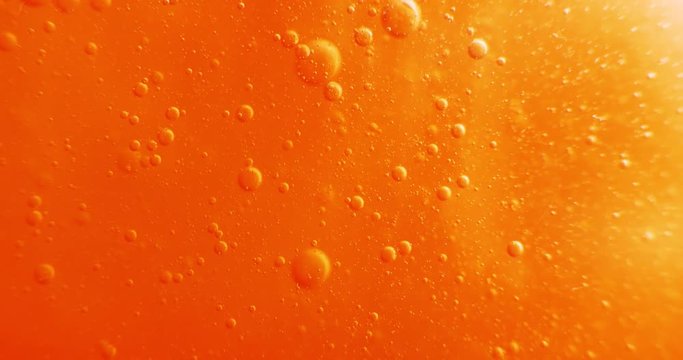 Extreme macro of bubbles in orange gel. 4K.