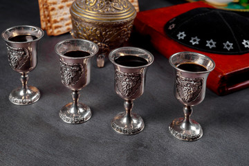 Pesach Passover symbols of great Jewish holiday. Traditional matzoh, matzah or matzo and wine in vintage silver glass.