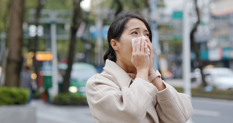 Fototapeta premium Woman sneeze in the city