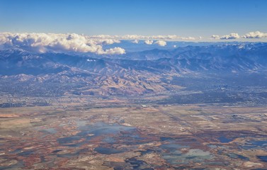 Aerial view of Wasatch Front Rocky Mountain landscapes on flight over Colorado and Utah during winter. Grand sweeping views near the Great Salt Lake, Utah Lake, Provo, Timpanogos, Lone and Twin Peaks 