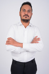 Studio shot of bearded Indian businessman with arms crossed