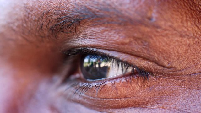 The blinking eye of a middle aged black man, close up detail