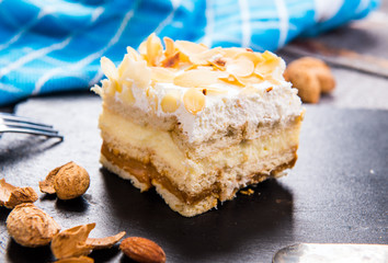 Homemade cake with whipped cream, almonds petals, toffi cream