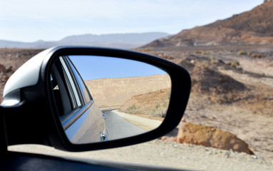 Fototapeta na wymiar side view mirror of a car , on road inauto,automobile,back,background,behind,blue,car,desert,drive,highway,landscape,looking,mirror,motion,nature,outdoor,rear,reflection,road,route,side,sky the desert