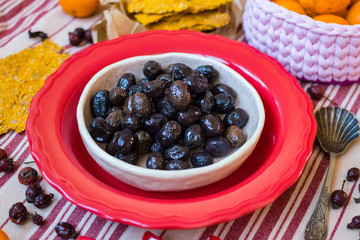 Black olives in bowl with crispy flat corn breads. Vegan and vegetarian healthy products