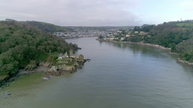 Aerial tracking forward up the mouth of the river Dart. Visible is the historic town of Dartmouth, and in the immediate vicinity is Dartmouth Castle