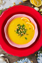 Peas yellow soup with curry and turmeric powder, lemon and greens in bowl. Vegan and vegetarian healthy food