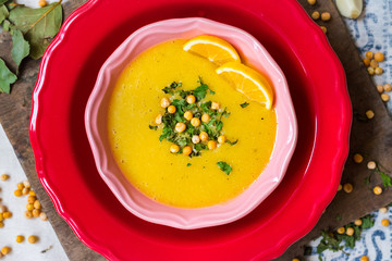 Peas yellow soup with curry and turmeric powder, lemon and greens in bowl. Vegan and vegetarian healthy food