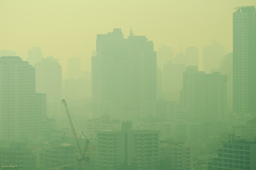 cityscape of high rise buildings in poor weather morning, haze of pollution covers city