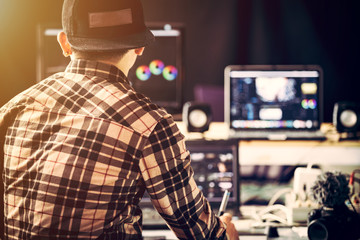 Content creators he is working in studio  and use laptop editing video footage upload to social media