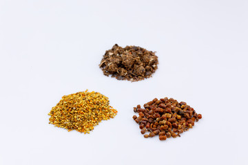 A sprinkle of pollen and propolis and pollen on a white background. Bee product. Close-up.