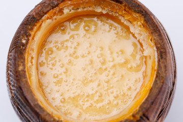 Wooden open barrel with fragrant fresh honey on a white background. Close-up.