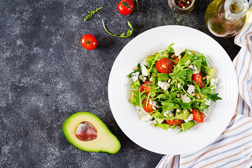 Dietary salad with tomatoes, blue cheese, avocado, arugula and pine nuts. Top view. Flat lay.