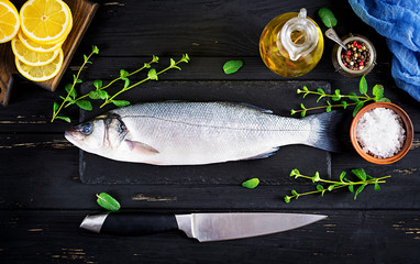 Raw fish. Sea bass on slate blackboard. Ingredients for cooking, grill, baked. Copy space. Top view