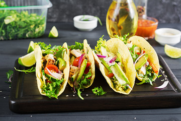 Mexican tacos with chicken meat, avocado, tomato, cucumber and red onion. Healthy tortilla. Wrap food. Taco