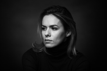 Dramatic black and white portrait of a beautiful woman on a dark background