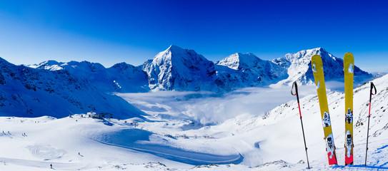 Ski in winter season, mountains and ski touring backcountry equipments on the top of snowy mountains in sunny day. South Tirol, Solda in Italy. - Powered by Adobe