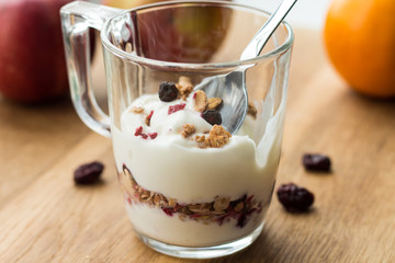 yogurt and muesli (crunchy) with dried berries in a glass cup, healthy food