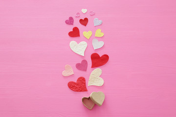 Valentine's day concept. Paper hearts over wooden pink background. Flat lay.