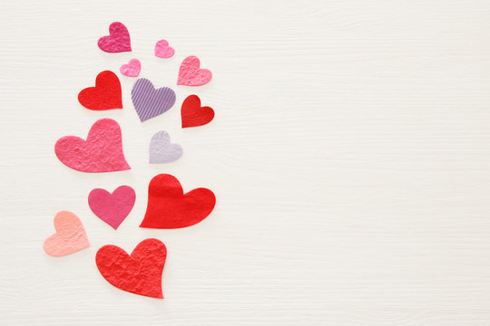 Valentine's day concept. Paper hearts over wooden white background. Flat lay.