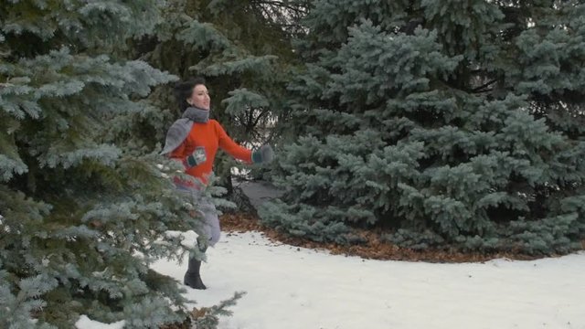 Woman is running in winter forest, beautiful landscape with snowy fir trees