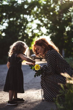 Mom and little daughter with a yellow rose