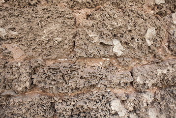 Closeup of brown porous stone textured wall. For background, product designs or skin